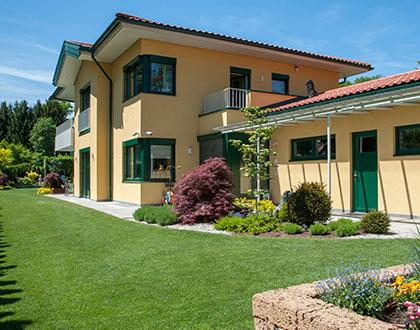 Gelbe Hausfassade mit grünen Fenstern